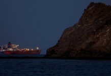 Iran attacks more ships, Dubai airport, warns U.S.-linked banks are next