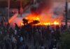 Anti-immigrant protesters clash with police, torch car at Belfast rally