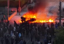 Anti-immigrant protesters clash with police, torch car at Belfast rally