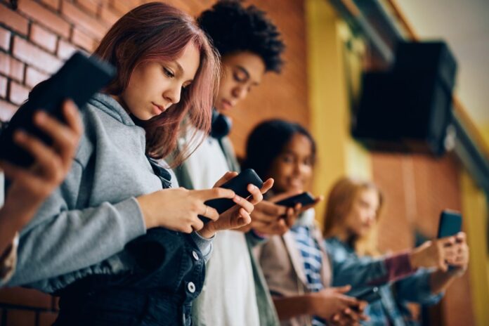 group-teenagers-using-mobile-phones-136918875.jpg