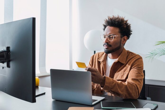Man-using-computer-at-home-office-holding-credit-card_Westend61.jpg